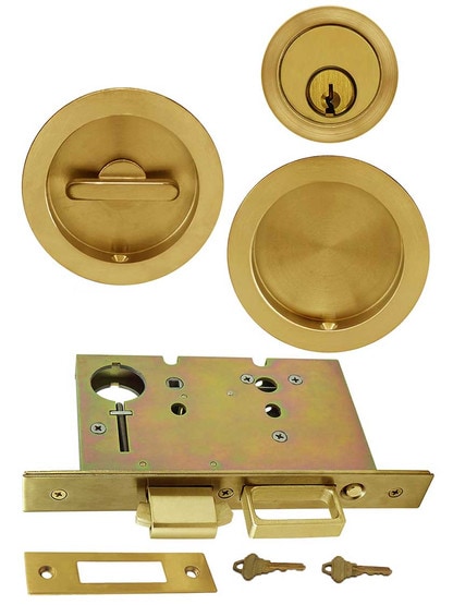 Premium Keyed Pocket-Door Mortise Lock Set with Round Pulls in Aged Brass.